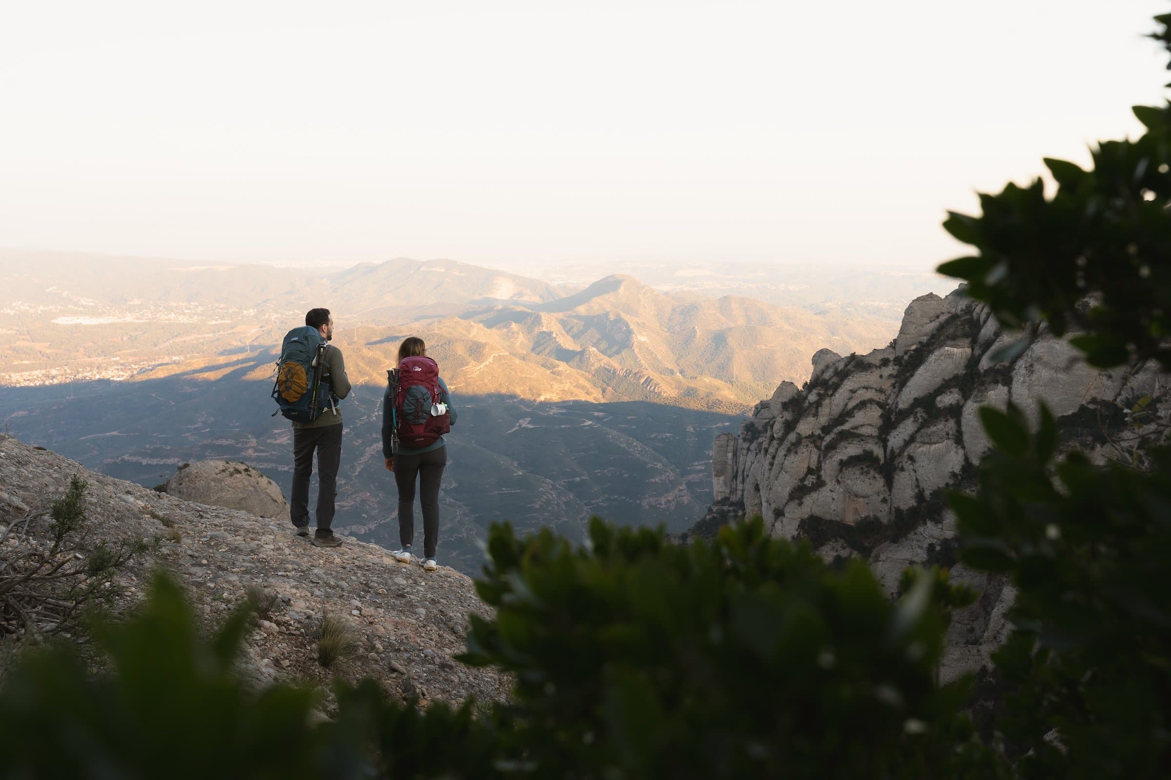 To personer på tur som ser utover fjellhmrisonten
