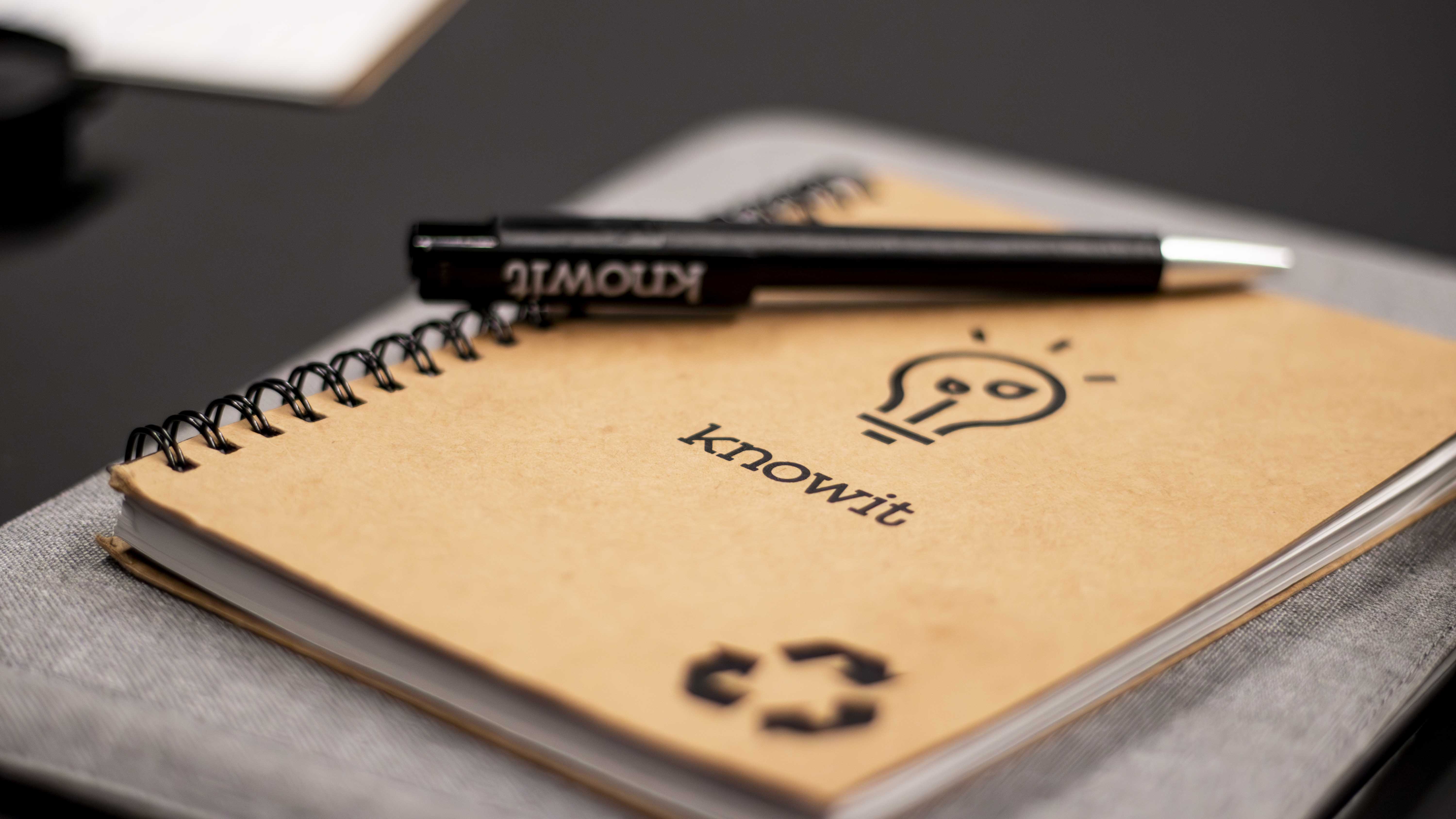 Bilde av notatbok og penn med Knowit logo